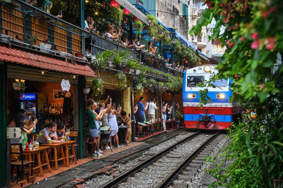 Tourists Taking Photos Near Hanoi Train Street Visitors actively photographing Hanoi Train Street railway tracks