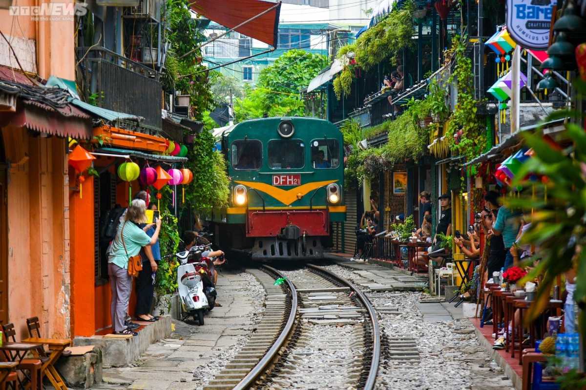 Tourists Enjoying Hanoi Train Street Rail Tracks Tourists walking and photographing on Hanoi Train Street’s rail tracks