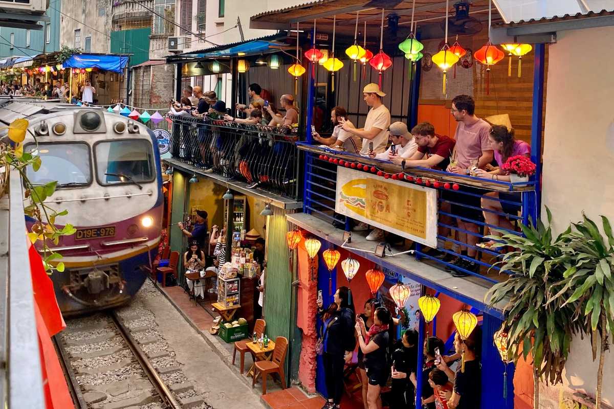 Hanoi Train Street Train Passing with Spectators People photographing and watching a train passing through Hanoi Train Street