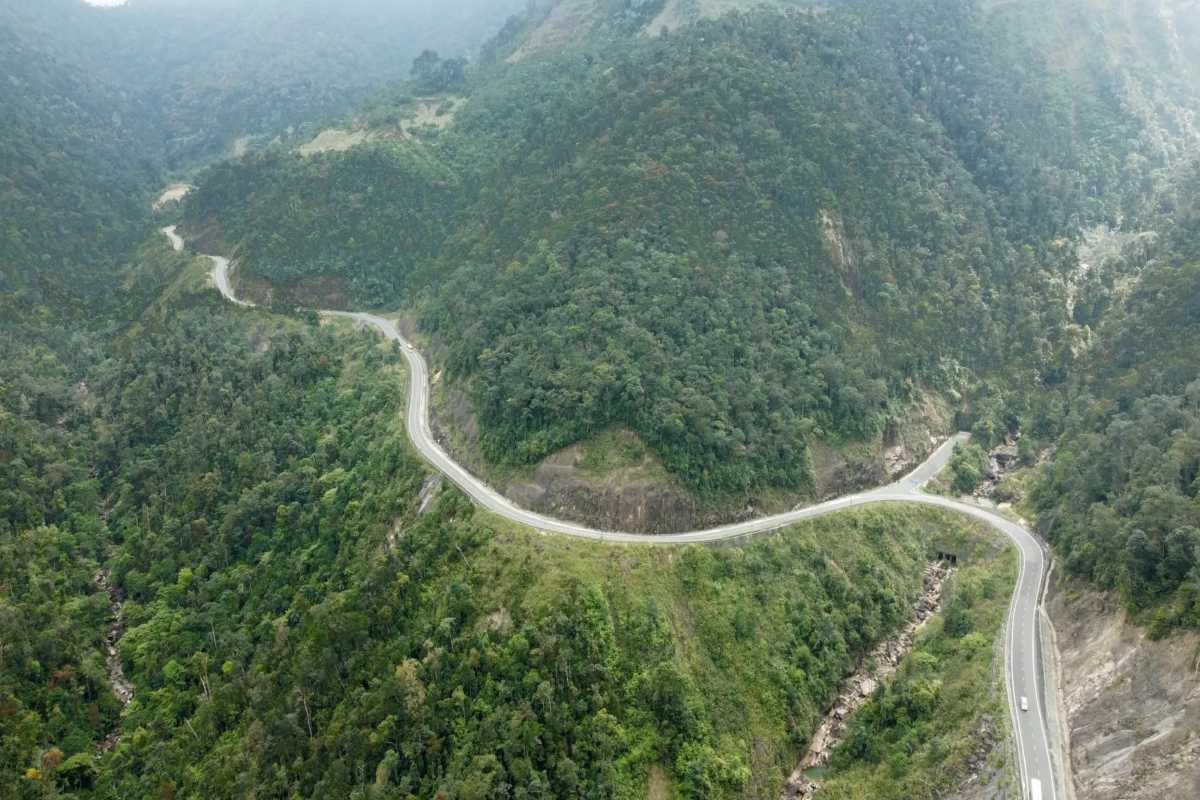 Remote road bends through highland Empty mountain road bending through green hills along Heaven Pass in Vietnam.