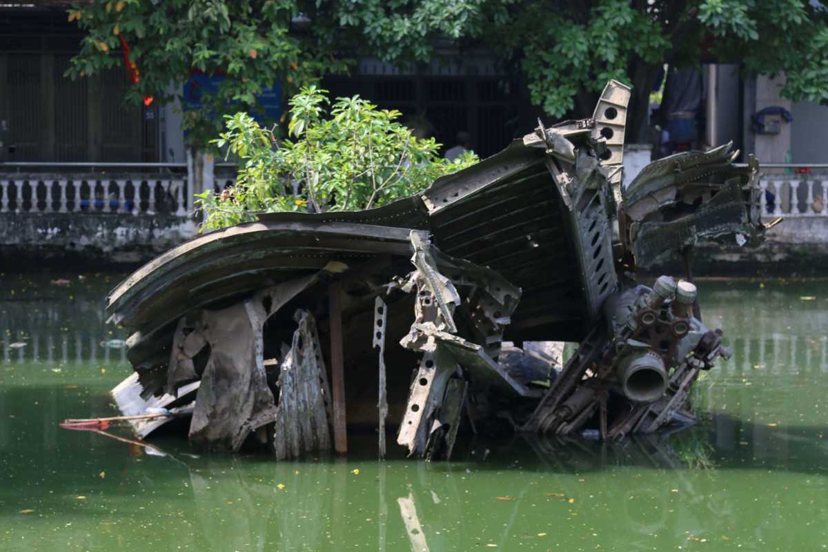 Historic B-52 Wreckage in Huu Tiep Lake Hanoi Historic B-52 plane wreckage in the middle of Huu Tiep Lake Hanoi with buildings and greenery in the background