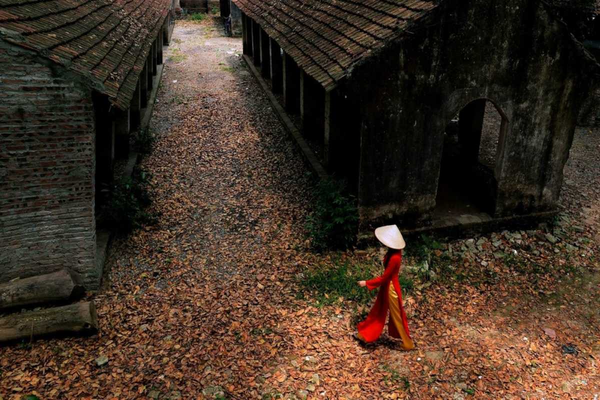 Historic Stone Warehouses in Ngoc Ha Flower Village Hanoi Old stone warehouse buildings at Ngoc Ha Flower Village Hanoi with fallen leaves, showcasing village heritage.