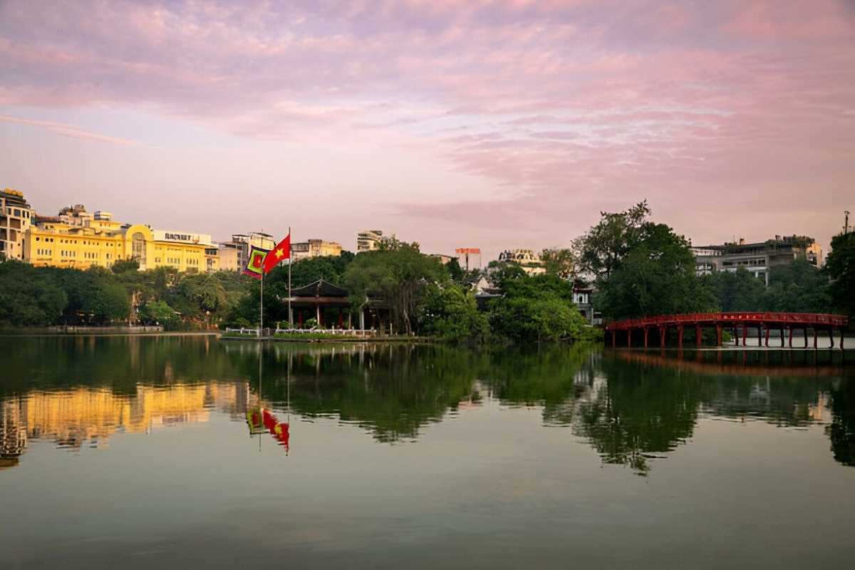 Hoan Kiem Lake Hanoi Sunset Panorama Panoramic view of Hoan Kiem Lake Hanoi at sunset with golden sky, calm waters, and green trees lining the shore.