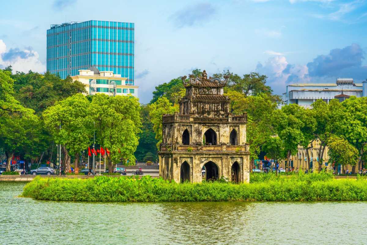 Turtle Tower on Hoan Kiem Lake Hanoi Turtle Tower standing on a small island in Hoan Kiem Lake Hanoi surrounded by lush greenery and urban skyline.