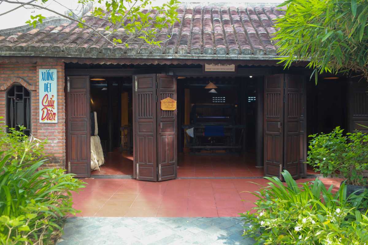 Hoi An Silk Village Traditional Workshop Front Wooden workshop building entrance surrounded by greenery at Hoi An Silk Village
