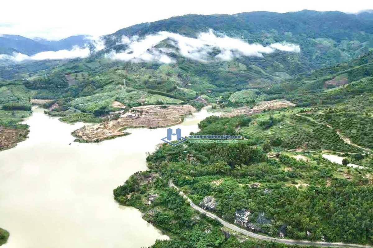Traditional Thatched Roof House by River in Hon Ba Reserve Thatched roof house near flowing river and greenery in Hon Ba Nature Reserve
