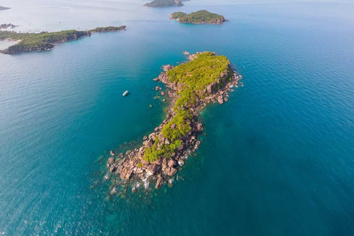 Hon Buom Island Phu Quoc Rocky Coastline Overhead shot of rocky coastline and lush greenery of Hon Buom Island surrounded by clear ocean.