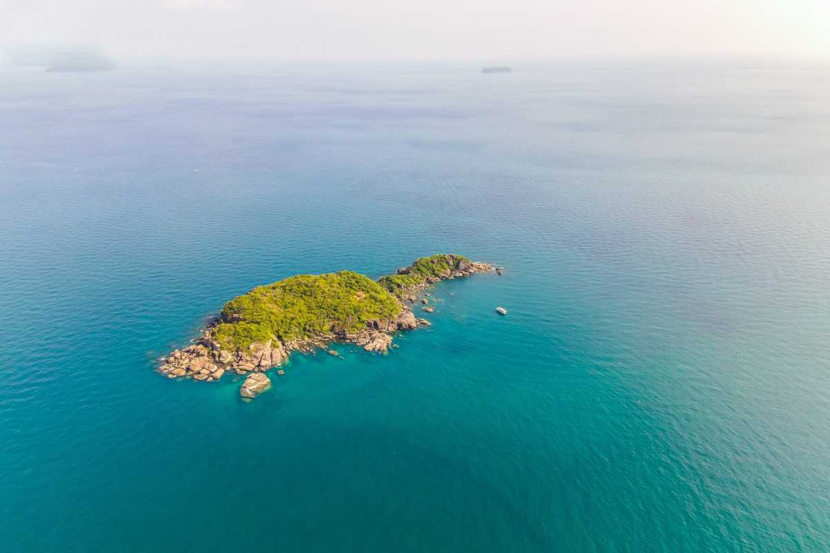 Hon Buom Island Phu Quoc Secluded Island Views Aerial image of Hon Buom Island showing secluded bays and dense forest in Phu Quoc waters.