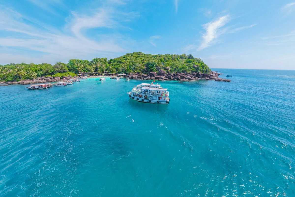 Hon Buom Island Phu Quoc Snorkeling and Marine Life Tourists snorkeling around coral reefs with a tour boat nearby at Hon Buom Island Phu Quoc.