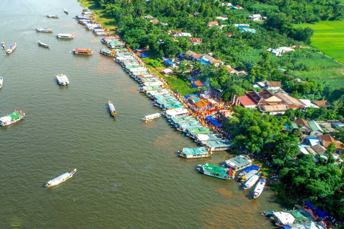 Hon Chen Temple Hue aerial view festival boats riverside gathering Hon Chen Temple Hue riverside lined with boats and crowds celebrating a festival from above
