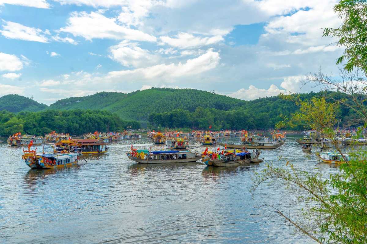 Hon Chen Temple Hue dragon boats festival gathering river panorama Hon Chen Temple Hue festival scene with many dragon boats floating on the Perfume River surrounded by hills