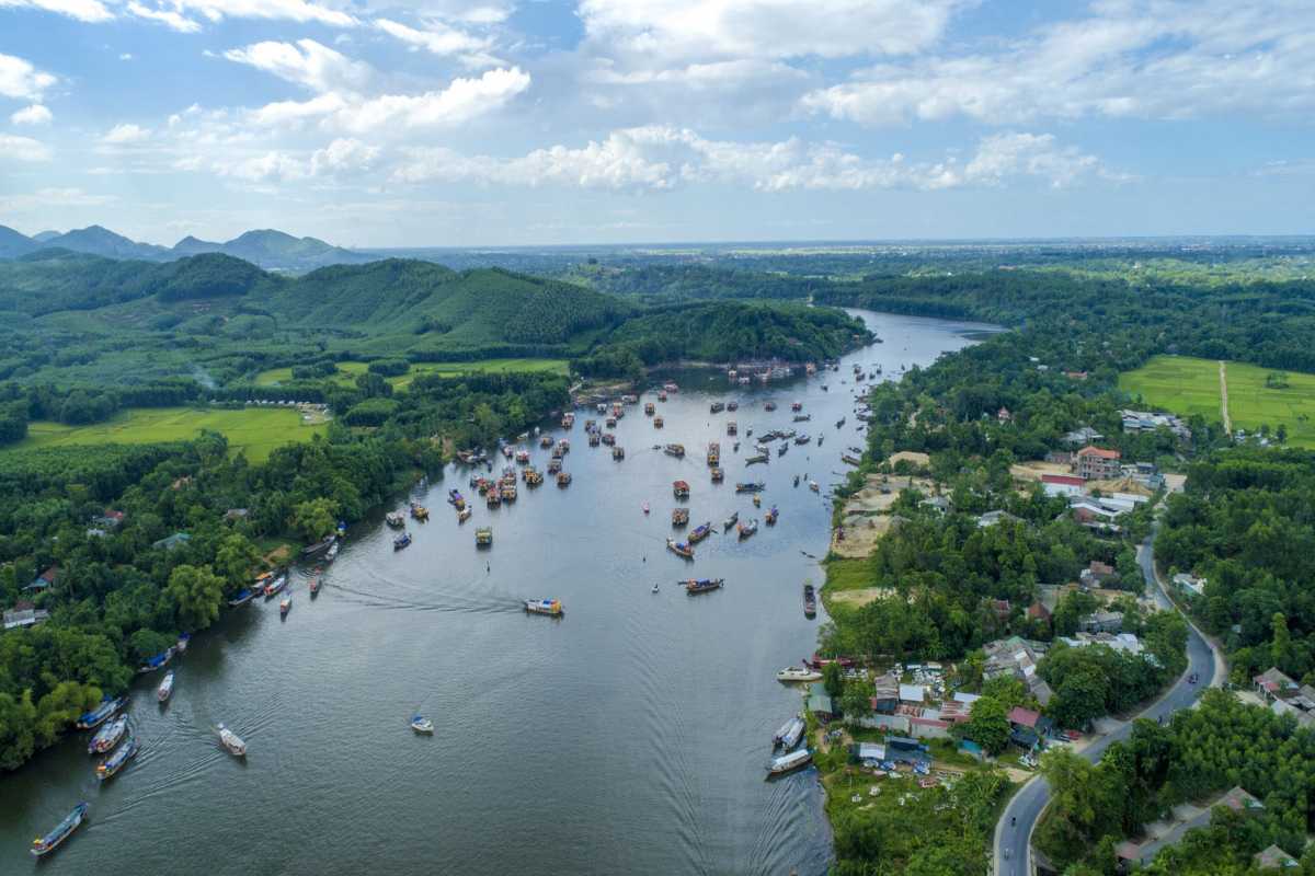 Hon Chen Temple Hue scenic river view festival boat activity Hon Chen Temple Hue scenic view of the river filled with festival boats, green landscape in background