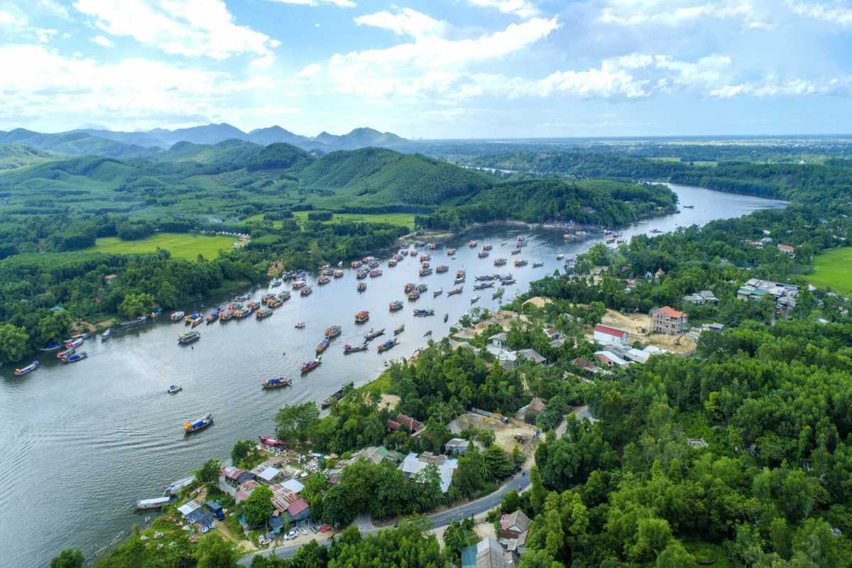 Hon Chen Temple Hue panoramic river boats lush green landscape Hon Chen Temple Hue surrounded by lush green hills and dozens of boats along the Perfume River