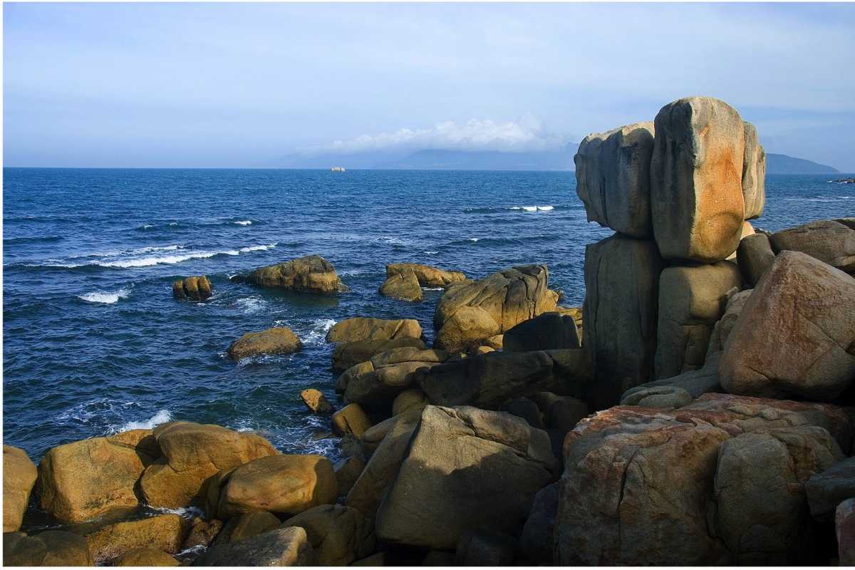 Hon Chong Promontory rock formations with city backdrop Rock formations at Hon Chong Promontory with Nha Trang city buildings visible