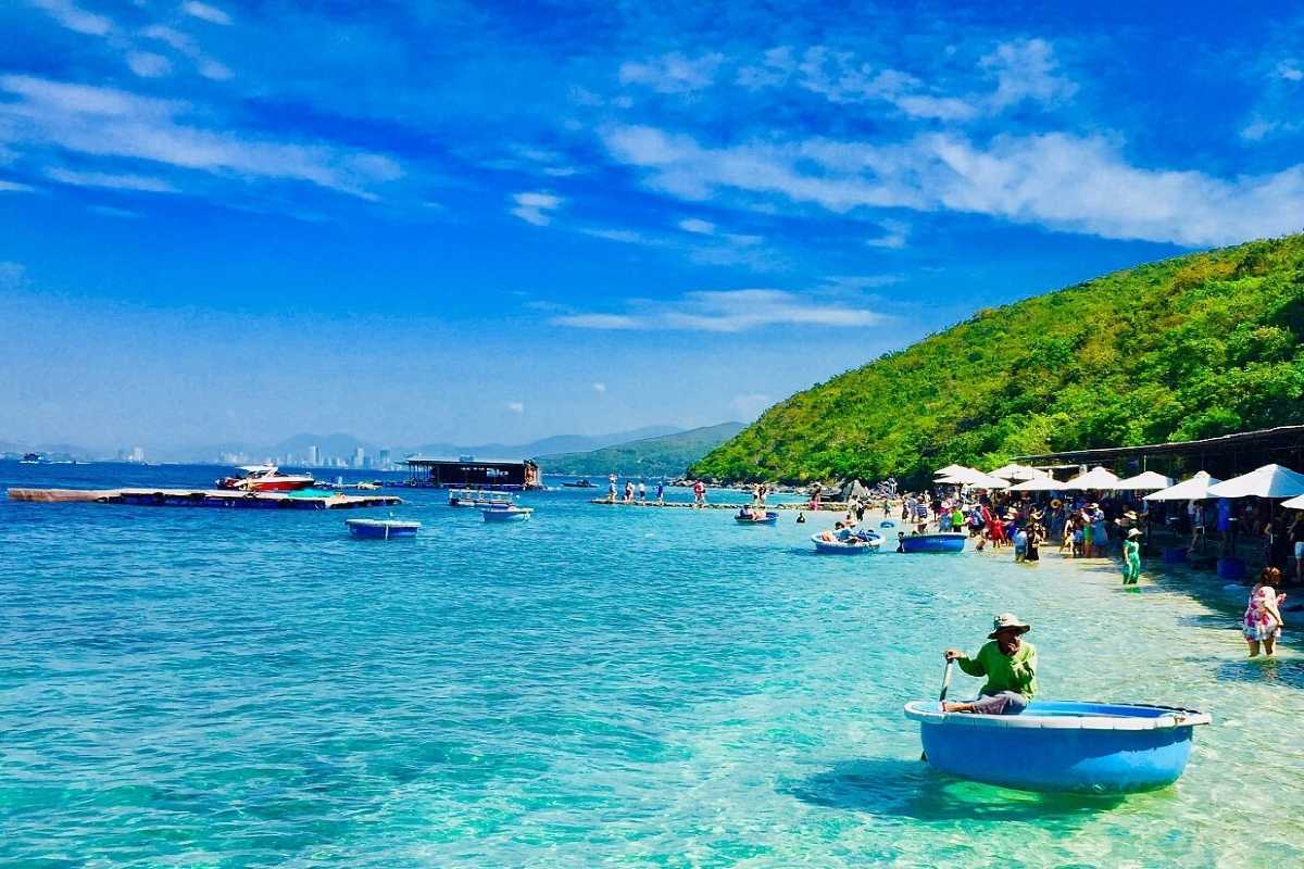 Hon Mieu Island popular beach with tourists and corals Tourists enjoying the popular Hon Mieu Island beach with crystal-clear waters and visible coral reefs.