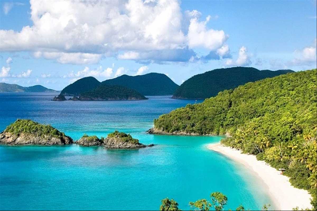 Wide-angle shot of Hon Mun Island’s lush green hills and turquoise bays taken from a distance.