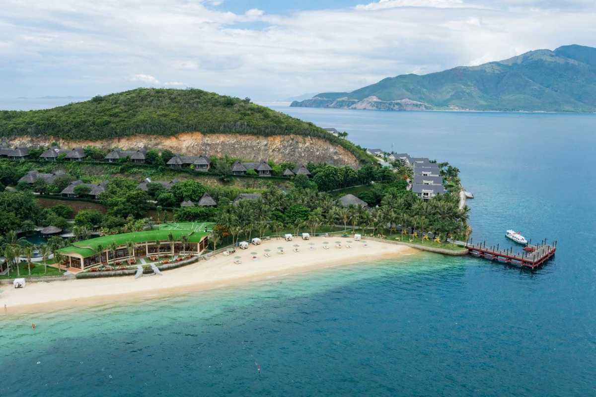 Beachfront resort and green roof café on Hon Tam Island Aerial view of a resort on Hon Tam Island featuring a green rooftop cafe and wide sandy beach.