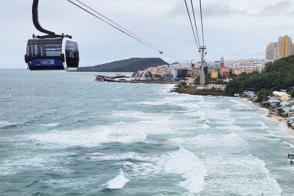 Hon Thom Cable Car cabin passing over the turquoise sea with Phu Quoc coastline in the background