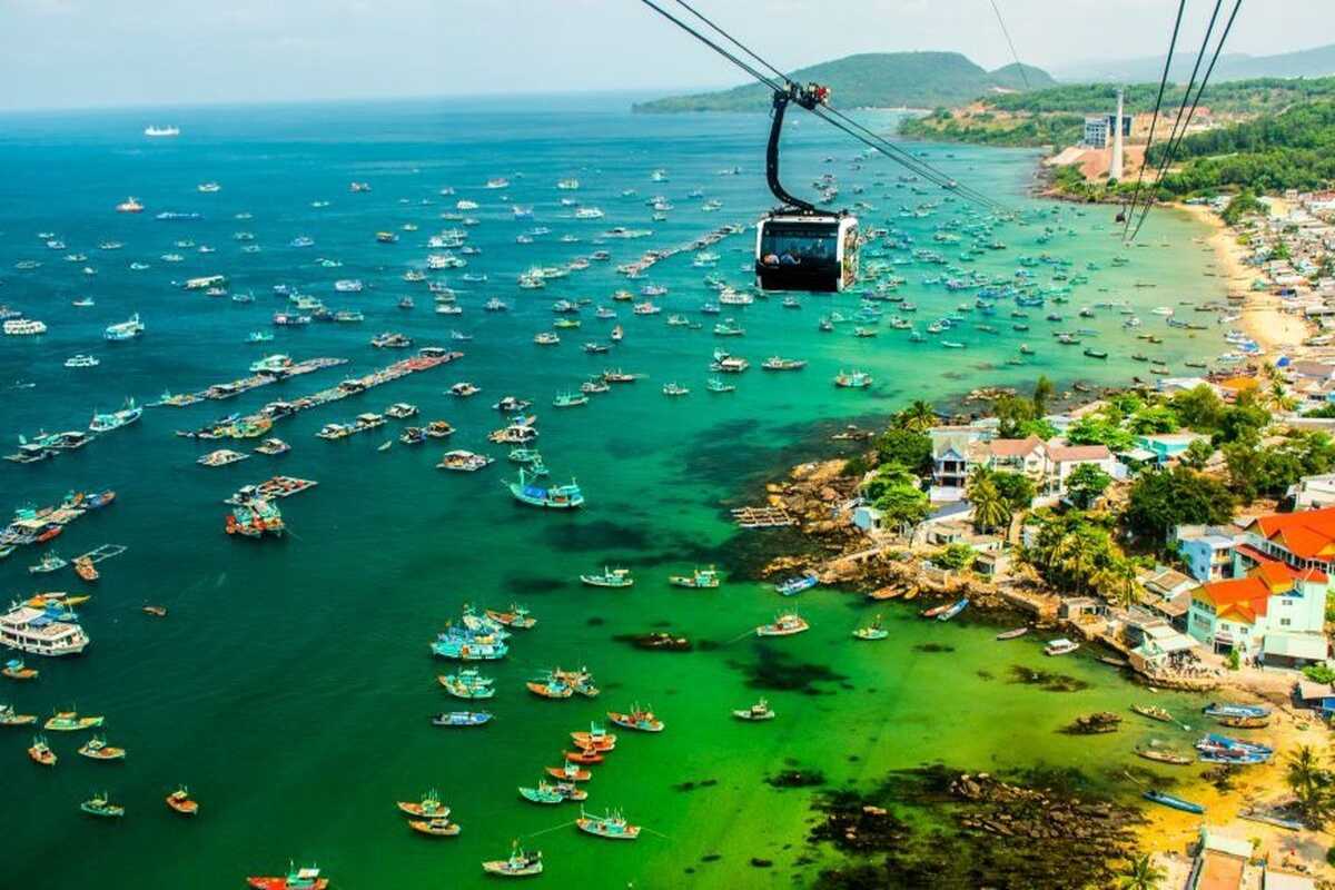 View of Hon Thom Cable Car Station over turquoise sea with many boats near Phu Quoc Island shore