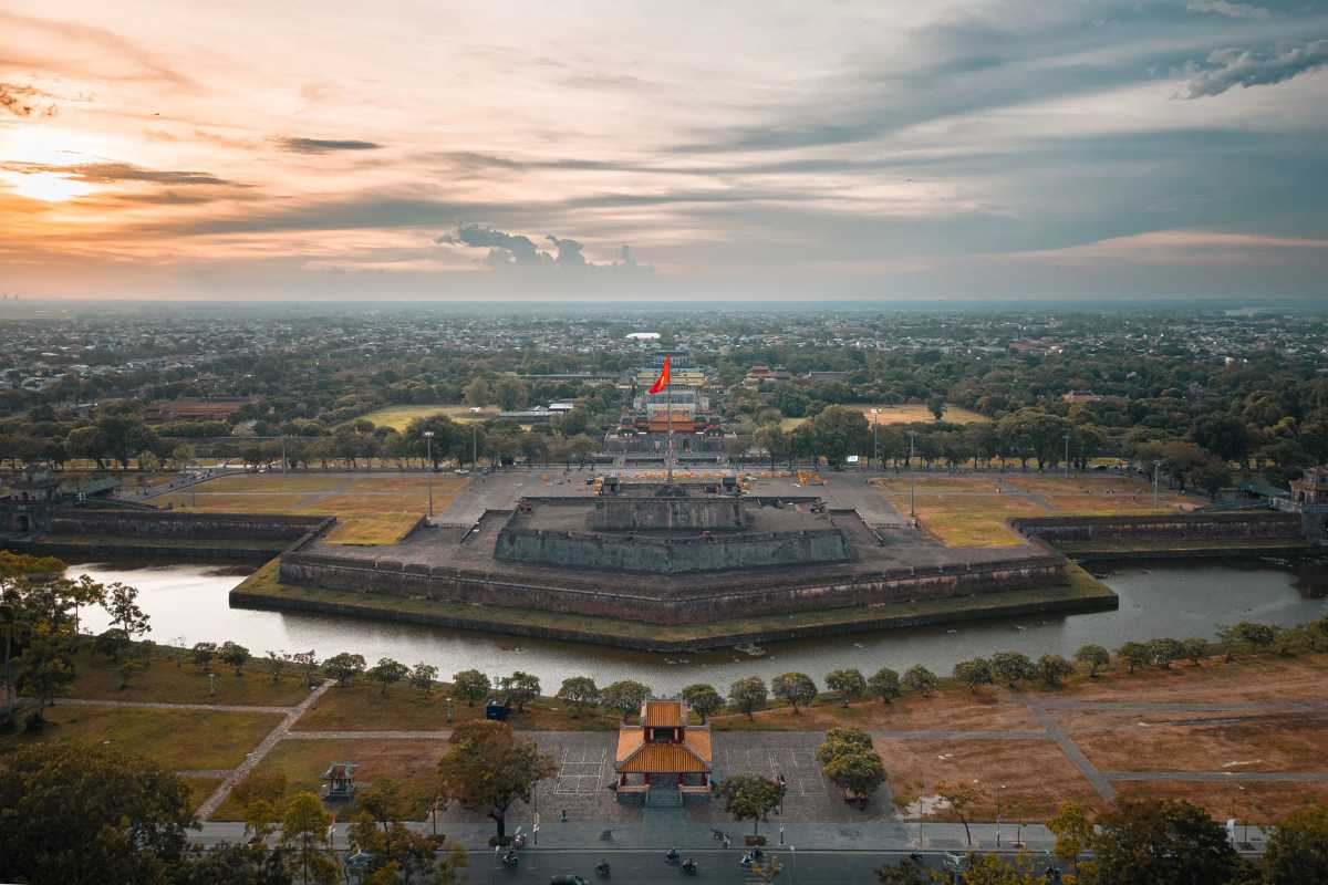 Hue Imperial City aerial view at sunset Hue Imperial City and Flag Tower viewed from above at sunset, highlighting the historic citadel, moat, and cityscape in central Hue.
