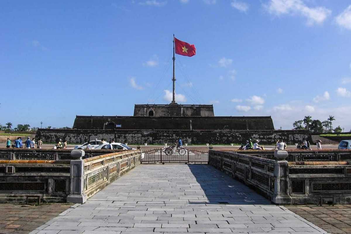 Historic Flag Tower and fortress walls at Hue Imperial City The historic Flag Tower of Hue Imperial City rises above thick fortress walls, attracting locals and tourists under a clear sky.
