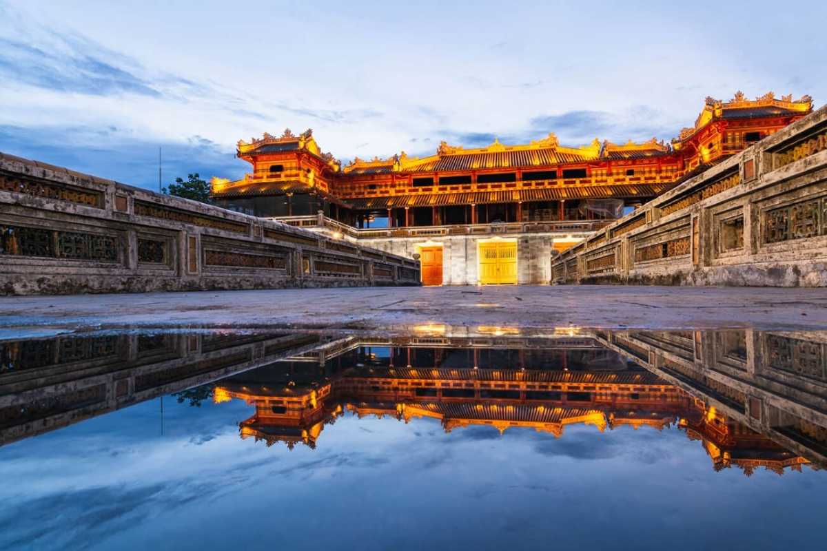 Night view of Hue Imperial City’s golden palace Hue Imperial City’s palace glows gold at night, reflected in a tranquil pool, capturing the enchanting atmosphere of Hue’s old capital.