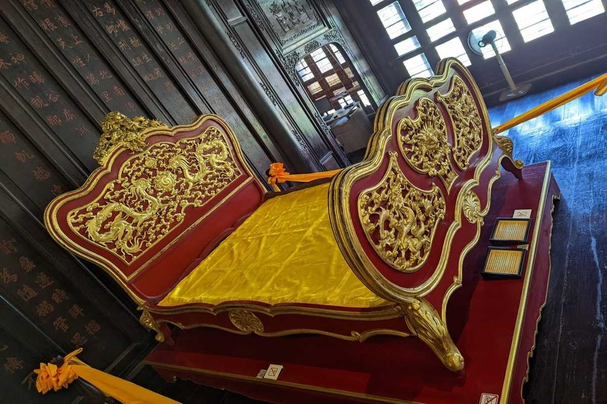 Golden imperial bed at Hue Museum of Royal Antiquities Ornate golden imperial bed with dragon motifs from the Nguyen Dynasty, featured at Hue Museum of Royal Antiquities