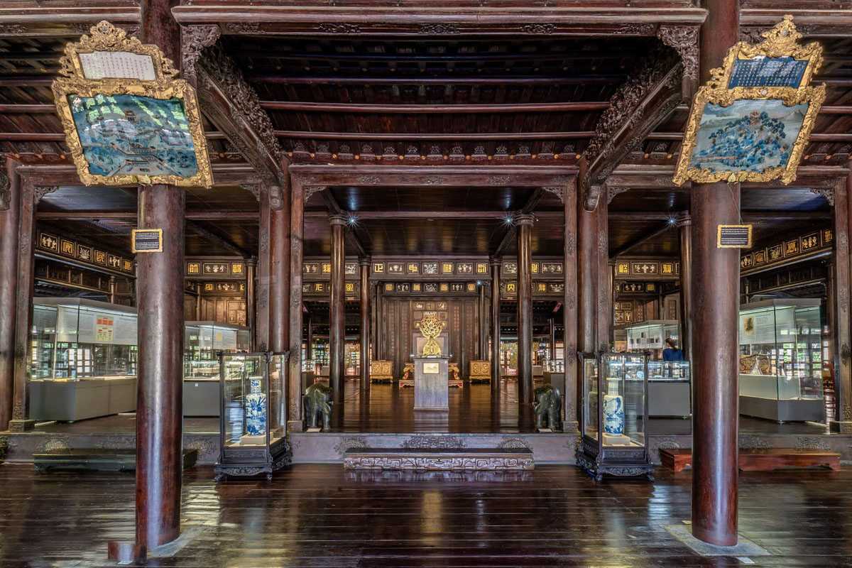 Main exhibition hall at Hue Museum of Royal Antiquities Main exhibition hall of Hue Museum of Royal Antiquities with wooden pillars, gold displays, and royal relics