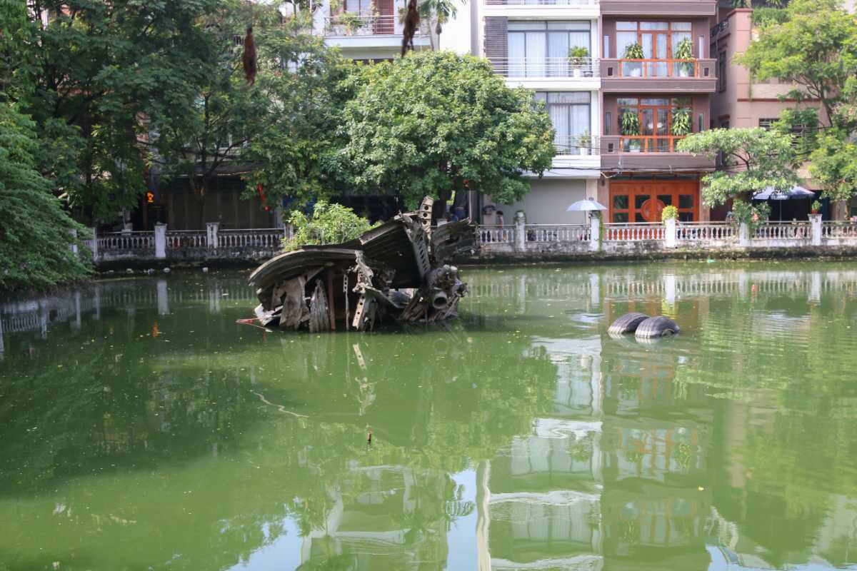 Huu Tiep B-52 Lake Hanoi with Plane Wreckage Partial wreckage of a B-52 bomber submerged in Huu Tiep B-52 Lake Hanoi surrounded by green water and trees