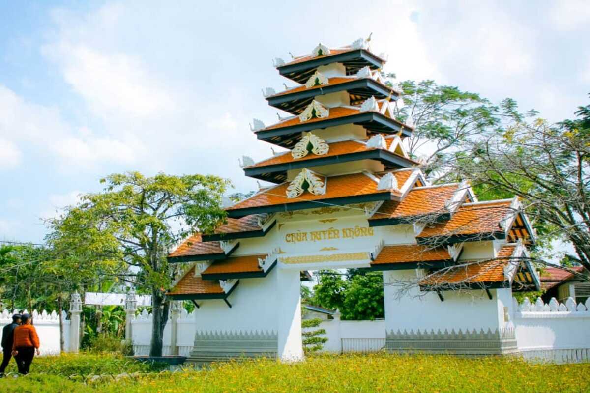 Huyen Khong Son Thuong Pagoda Hue ornate entrance gate and temple grounds Huyen Khong Son Thuong Pagoda Hue ornate multi-tiered entrance gate with white walls and temple garden in the background