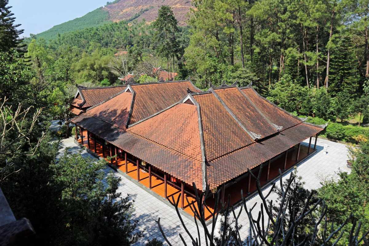 Huyen Khong Son Thuong Pagoda Hue traditional main building in forest setting Huyen Khong Son Thuong Pagoda Hue traditional main building with red-tiled roof, surrounded by dense green forest and mountain hills