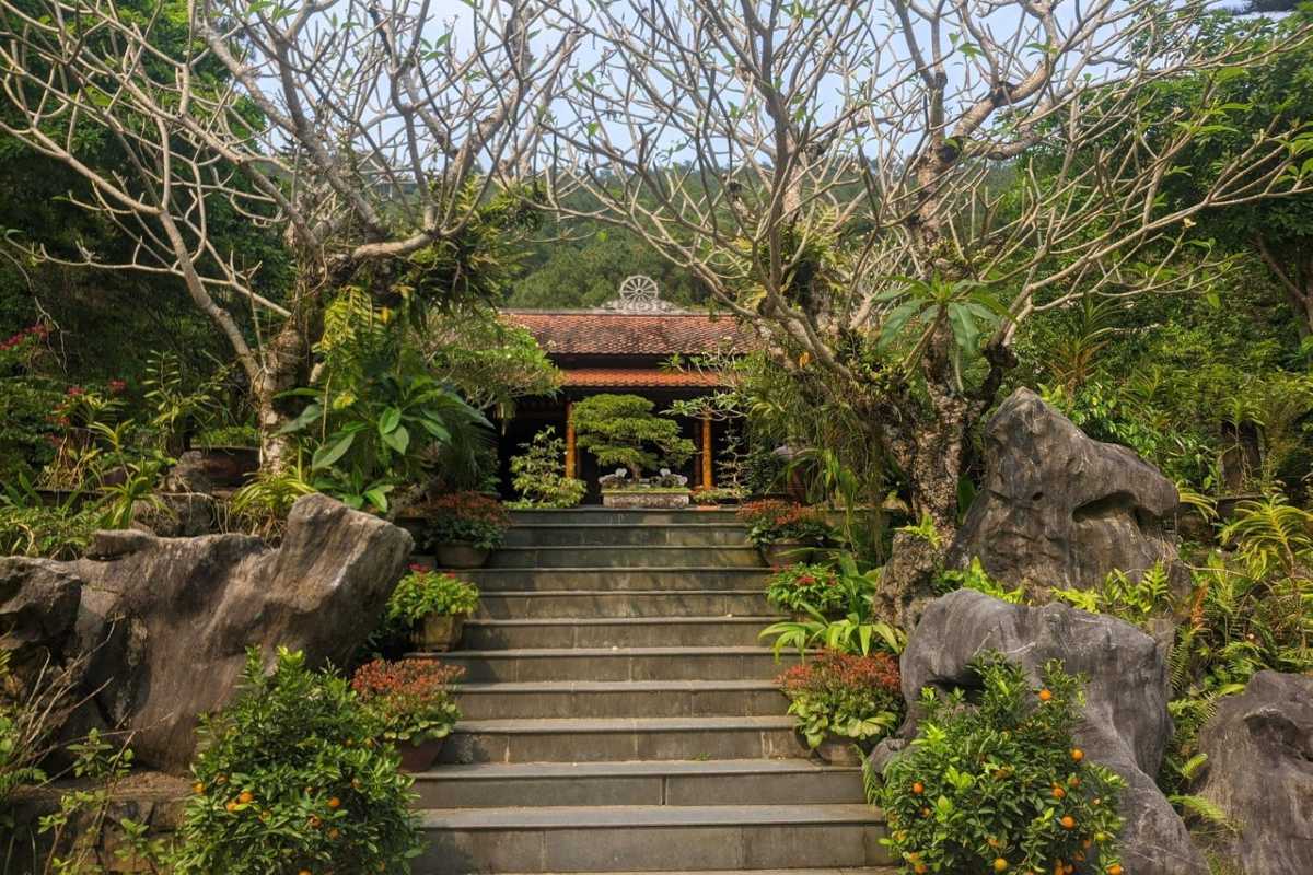 Huyen Khong Son Thuong Pagoda Hue stone steps leading to Zen garden Huyen Khong Son Thuong Pagoda Hue features stone steps lined with flowering trees, lush Zen garden, and peaceful mountain scenery