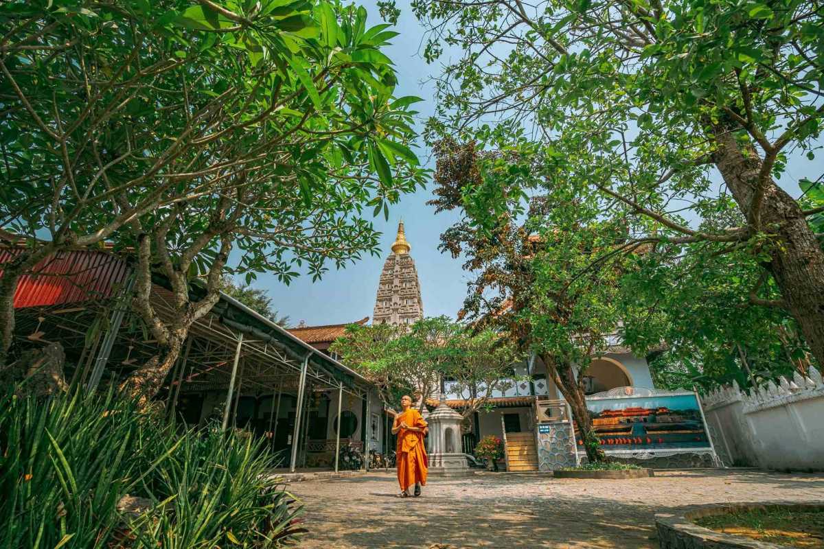 Huyen Khong Son Thuong Pagoda Hue tranquil courtyard with Buddhist monk Huyen Khong Son Thuong Pagoda Hue features a peaceful courtyard, Buddhist monk in orange robes, lush greenery, and serene temple vibe