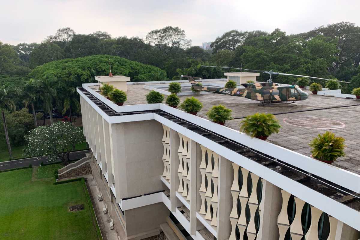Helicopter on Independence Palace Saigon Roof Helicopter displayed on the roof of Independence Palace Saigon surrounded by green trees