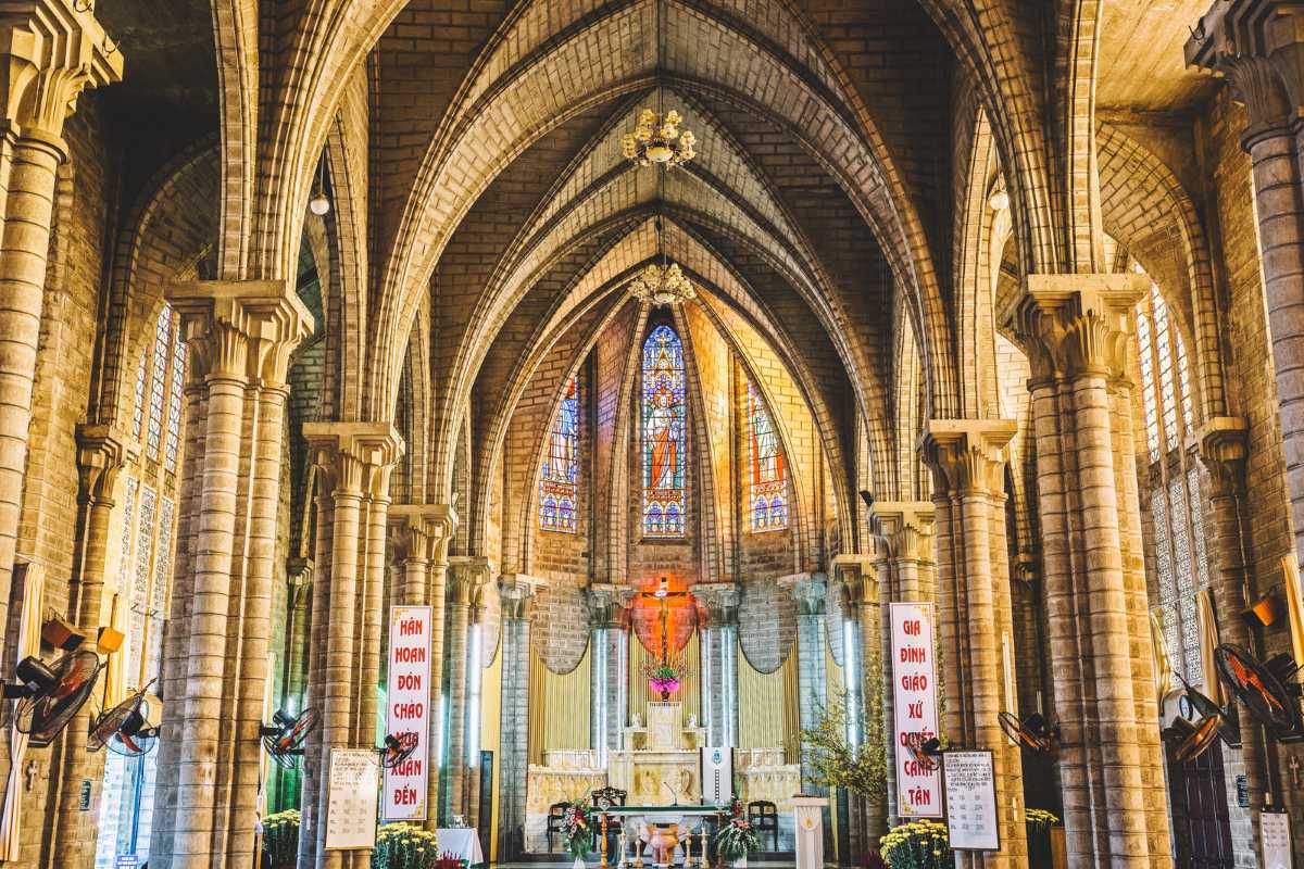 Interior view of Nha Trang Mountain Church with Gothic arches and stained-glass windows behind the altar