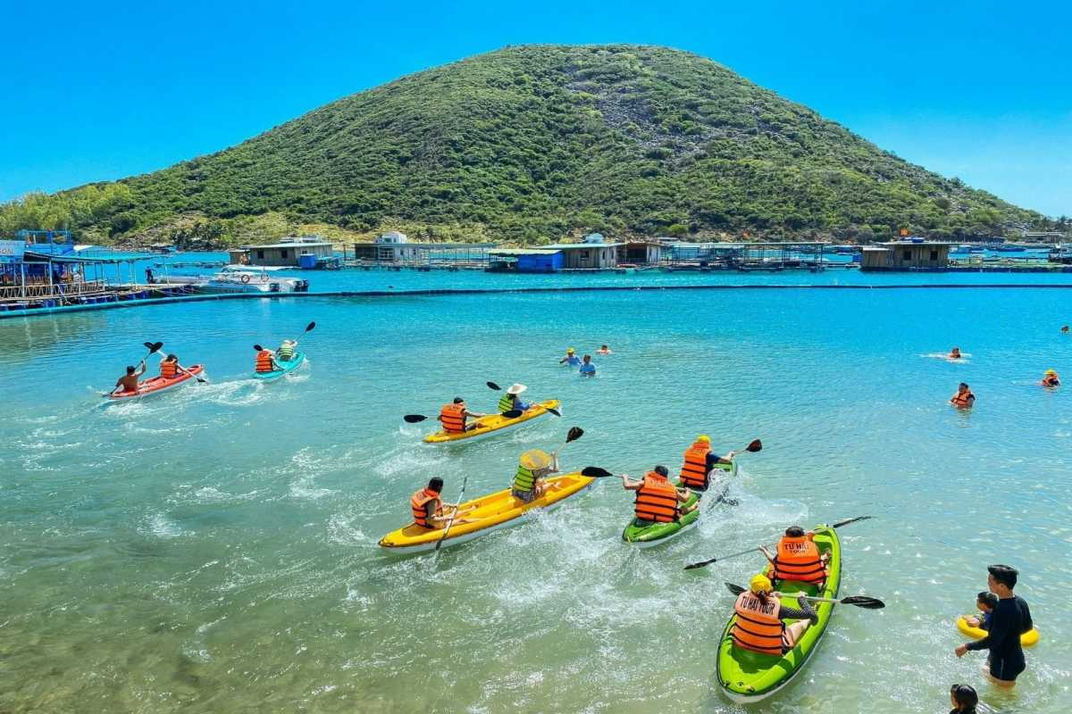 Kayaking and Family Fun at Robinson Beach Nha Trang Families kayaking together on clear waters with green hills surrounding Robinson Beach Nha Trang