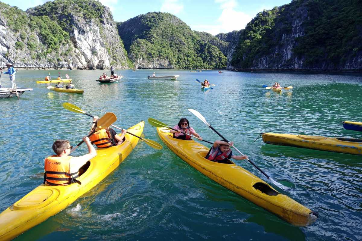 Kayaking Luon Cave Halong Bay group kayaking Group kayaking at Luon Cave Halong Bay enjoying a vibrant paddle in yellow kayaks