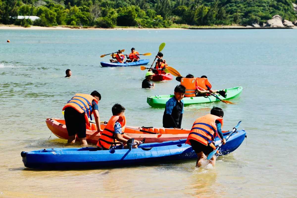 Kayaking Activities on Orchid Stream Island Nha Trang Visitors kayaking in calm shallow waters along the shore of Orchid Stream Island in Nha Trang