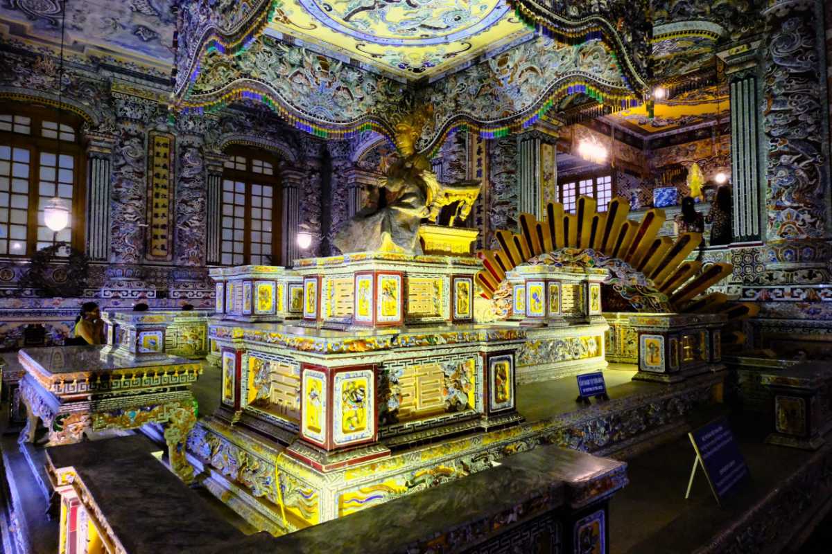 Ornate Interior of Khai Dinh Tomb Hue - Emperor’s Altar Lavishly decorated main chamber of Khai Dinh Tomb in Hue, featuring a golden statue and colorful imperial motifs.