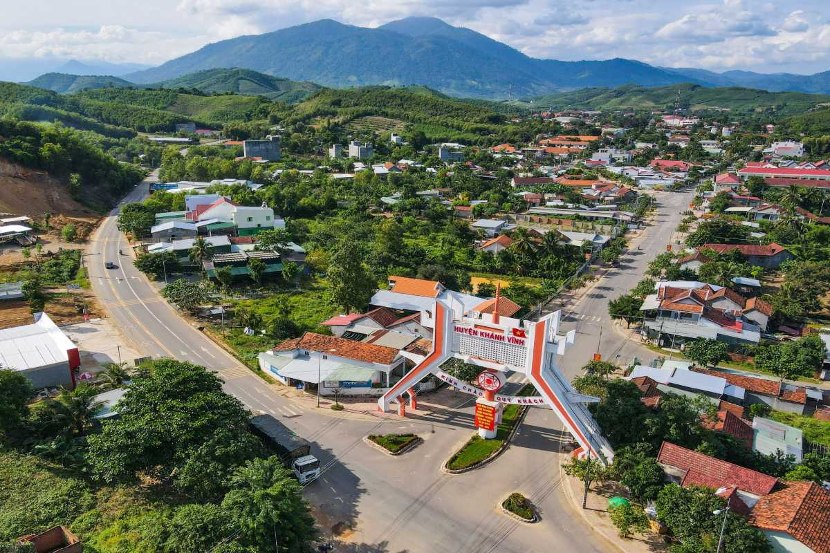 Entrance gate of Khanh Vinh District Main gateway arch welcoming visitors to Khanh Vinh with mountains in the background