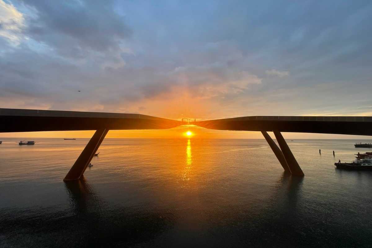 Sunrise view of Kiss Bridge on Phu Quoc Island with vibrant sky and calm sea