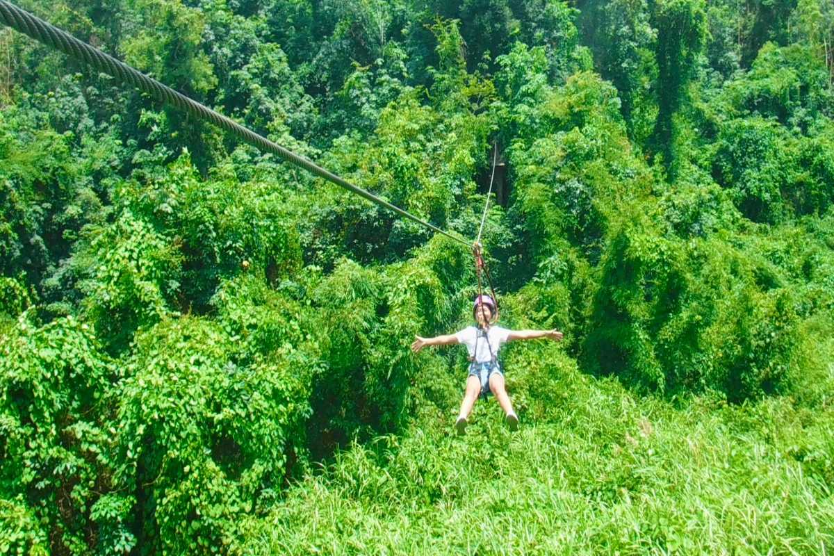 Kong Forest Scenic Zipline Flight Young woman enjoying a scenic zipline ride over Kong Forest canopy at Hon Ba Nature Reserve