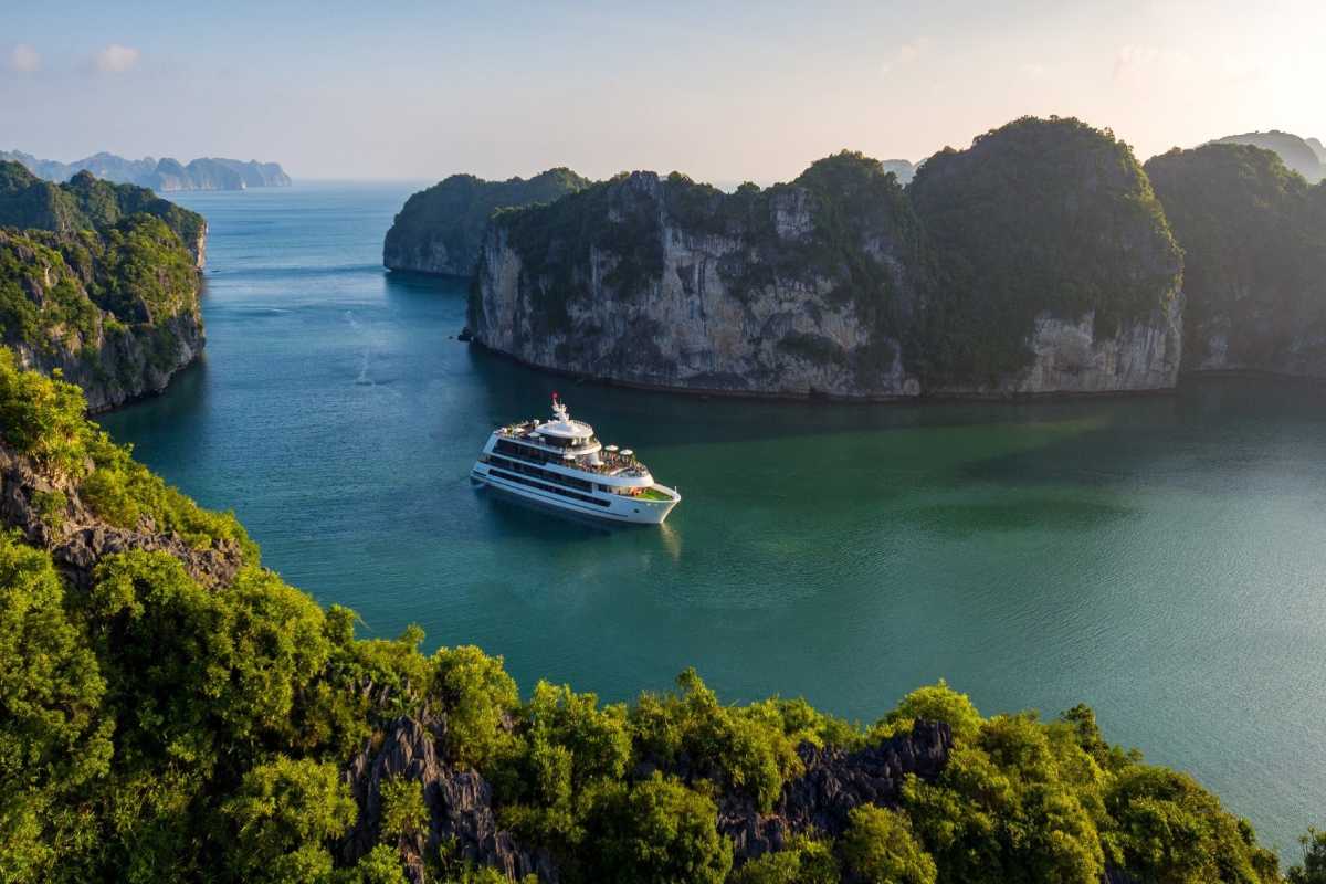 Lan Ha Bay Vietnam luxury cruise ship in calm bay A luxury white cruise ship anchored peacefully among towering islets in Lan Ha Bay Vietnam