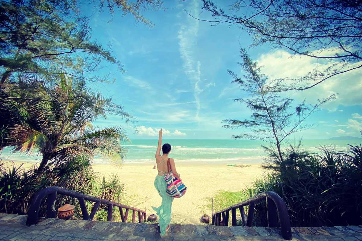 Lang Co Beach Hue stairway leading to sandy shore and sea Lang Co Beach Hue displays a scenic stairway descending to a broad sandy beach and calm blue sea, framed by tropical foliage and open sky.