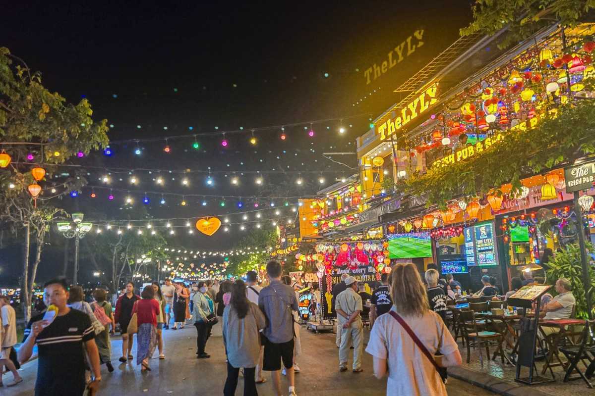 Lantern-lit Street Path with Tourists in Hoi An Groups of tourists walking beneath colorful hanging lanterns in a street during Hoi An Night Market
