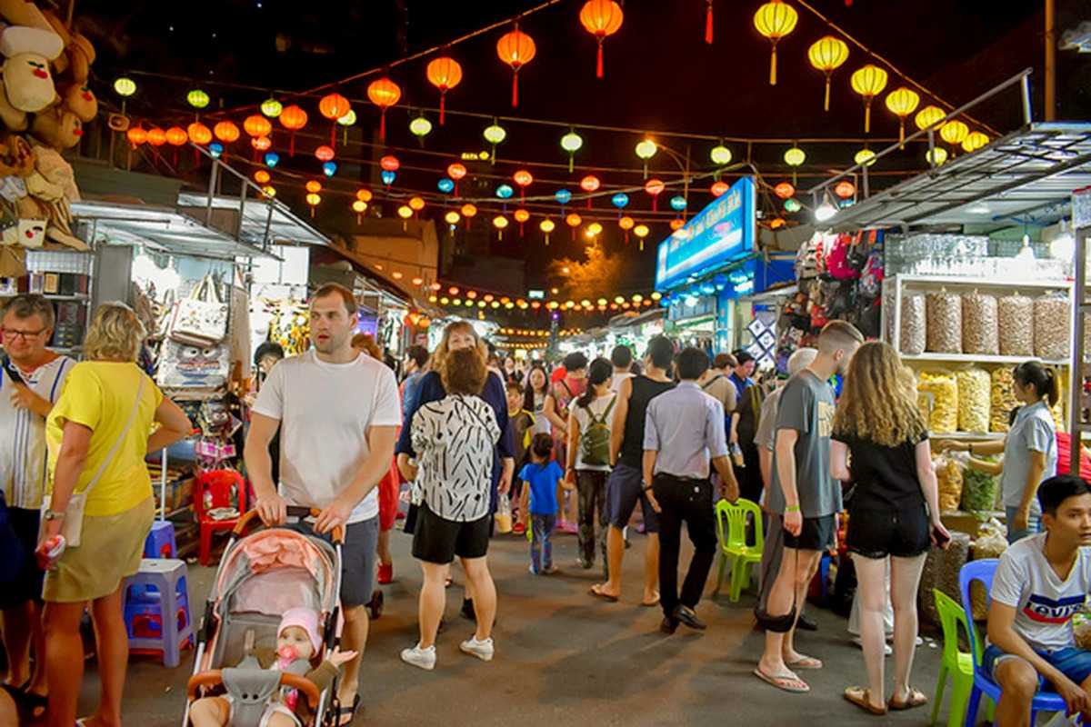 Lantern Lights Over Nha Trang Night Market Visitors walking under colorful lanterns at Nha Trang Night Market at night