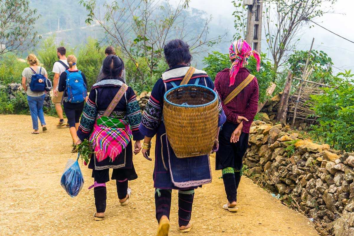 Lao Chai Village Sapa Hmong women and visitors walking Lao Chai Village Sapa Hmong women in ethnic dress walking with tourists along a rural village path