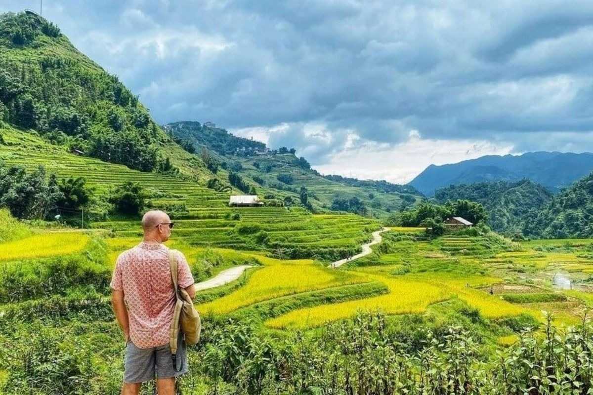 Lao Chai Village Sapa scenic trails and trekking routes Lao Chai Village Sapa trekking trail winds through green rice terraces with mountains under dramatic sky
