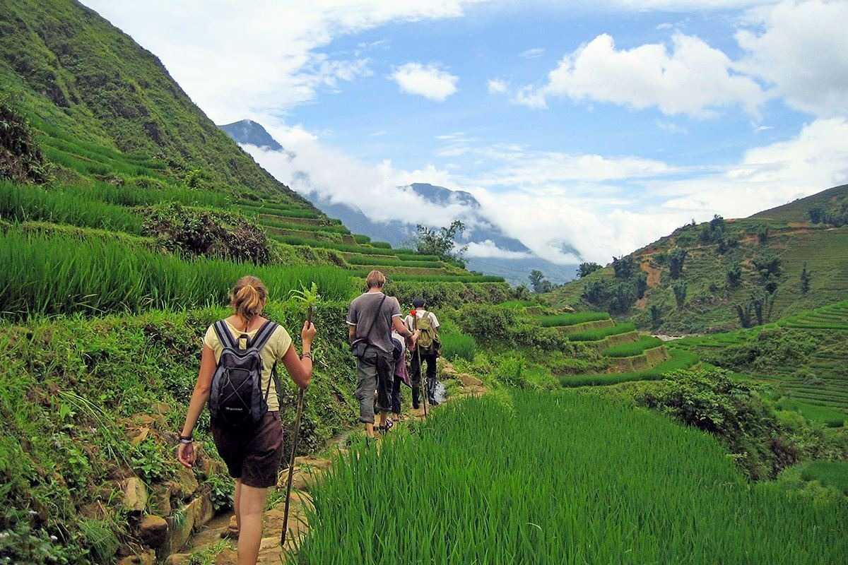 Lao Chai Village Sapa trekking through lush green hills Lao Chai Village Sapa travelers trekking on footpaths among lush green hills and terraced paddies