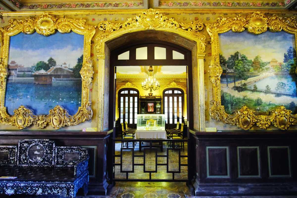 Lavish Interior Room with Gold Decor at An Dinh Palace Lavish interior room with golden decorations and wall paintings inside An Dinh Palace in Hue